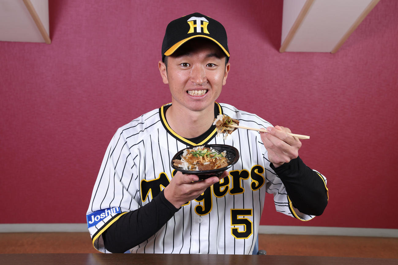 近本のさっぱり牛カルビ丼～淡路島産たまねぎ盛り～を食べる近本（甲子園球場提供）