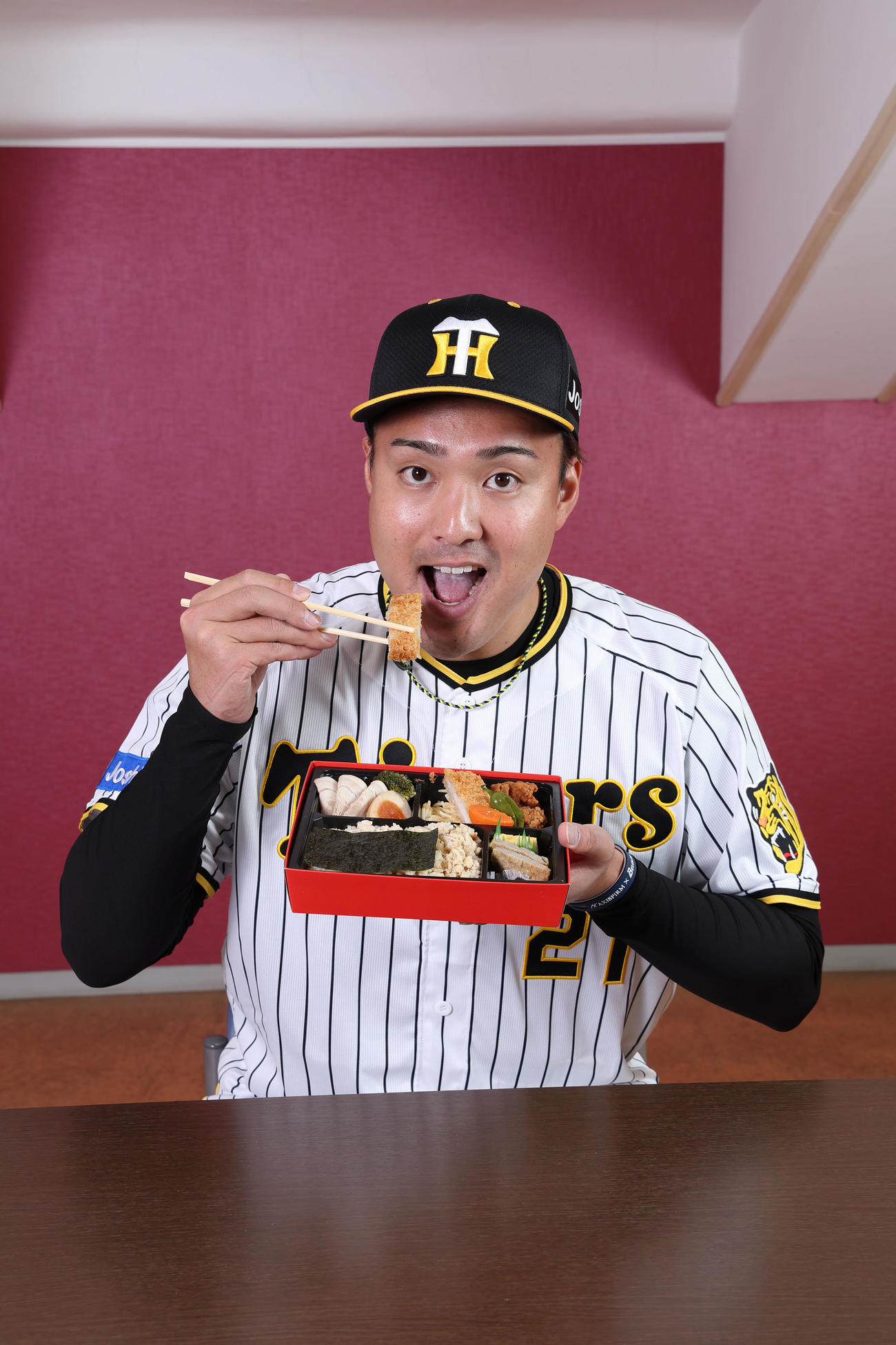秋山×ティモンディ食べればわかる！愛媛たっぷり弁当を食べる秋山（甲子園球場提供）