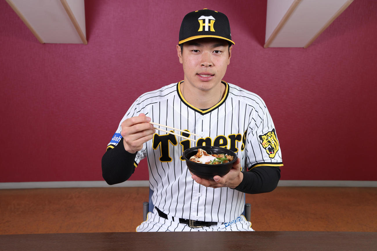 サトテルのWチキン輝（テリ）ヤキ丼を食べる佐藤輝（甲子園球場提供）
