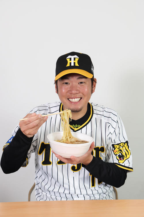 勇ちゃんの背脂醤油ラーメンを食べる西勇（甲子園球場提供）
