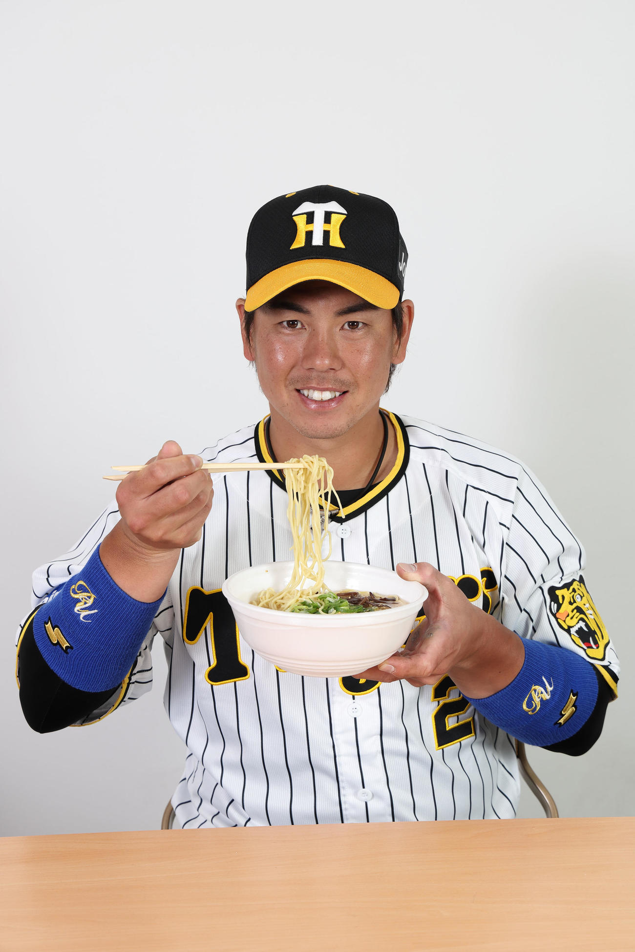梅野の博多屋台風豚骨ラーメンを食べる梅野（甲子園球場提供）