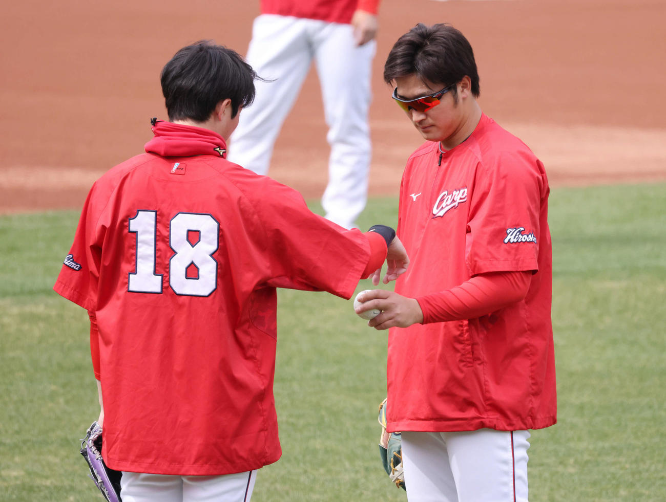 森下（左）にボールの握りを確認する床田（撮影・加藤孝規）
