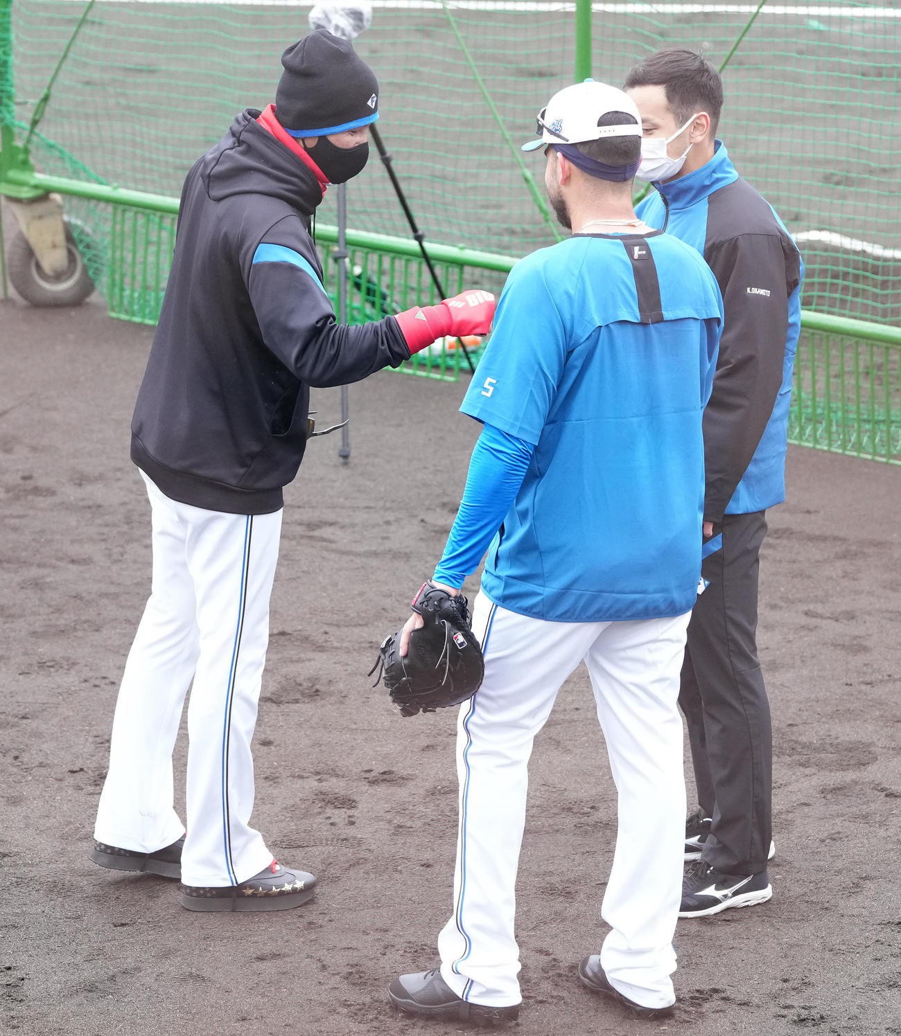 試合前練習で日本ハム・ヌニエス（手前）とグータッチする新庄監督（左）（撮影・鈴木みどり）