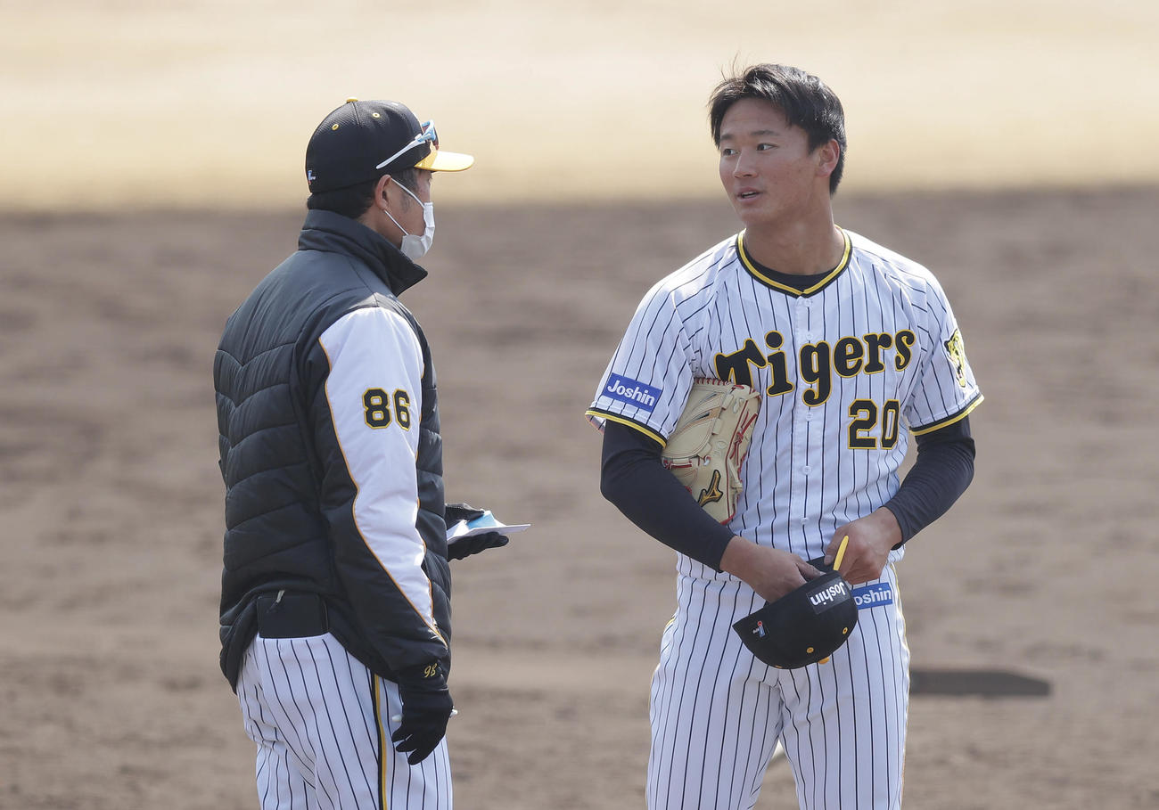 シート打撃の登板を終え、阪神安藤投手コーチ（左）と言葉を交わす森木（撮影・前田充）