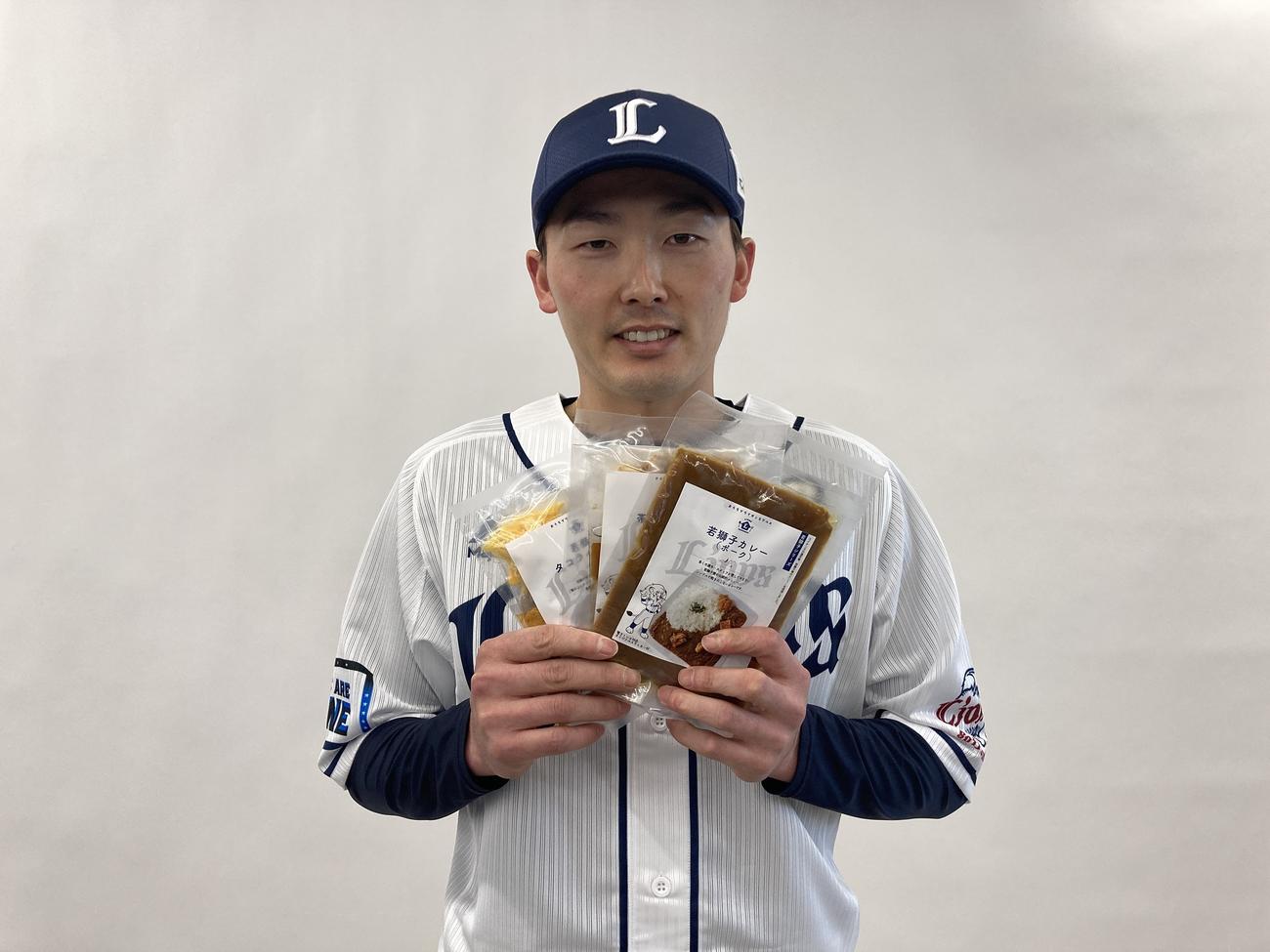 ベルーナドームで売られている球場グルメの冷凍食品を手にする西武源田（球団提供）