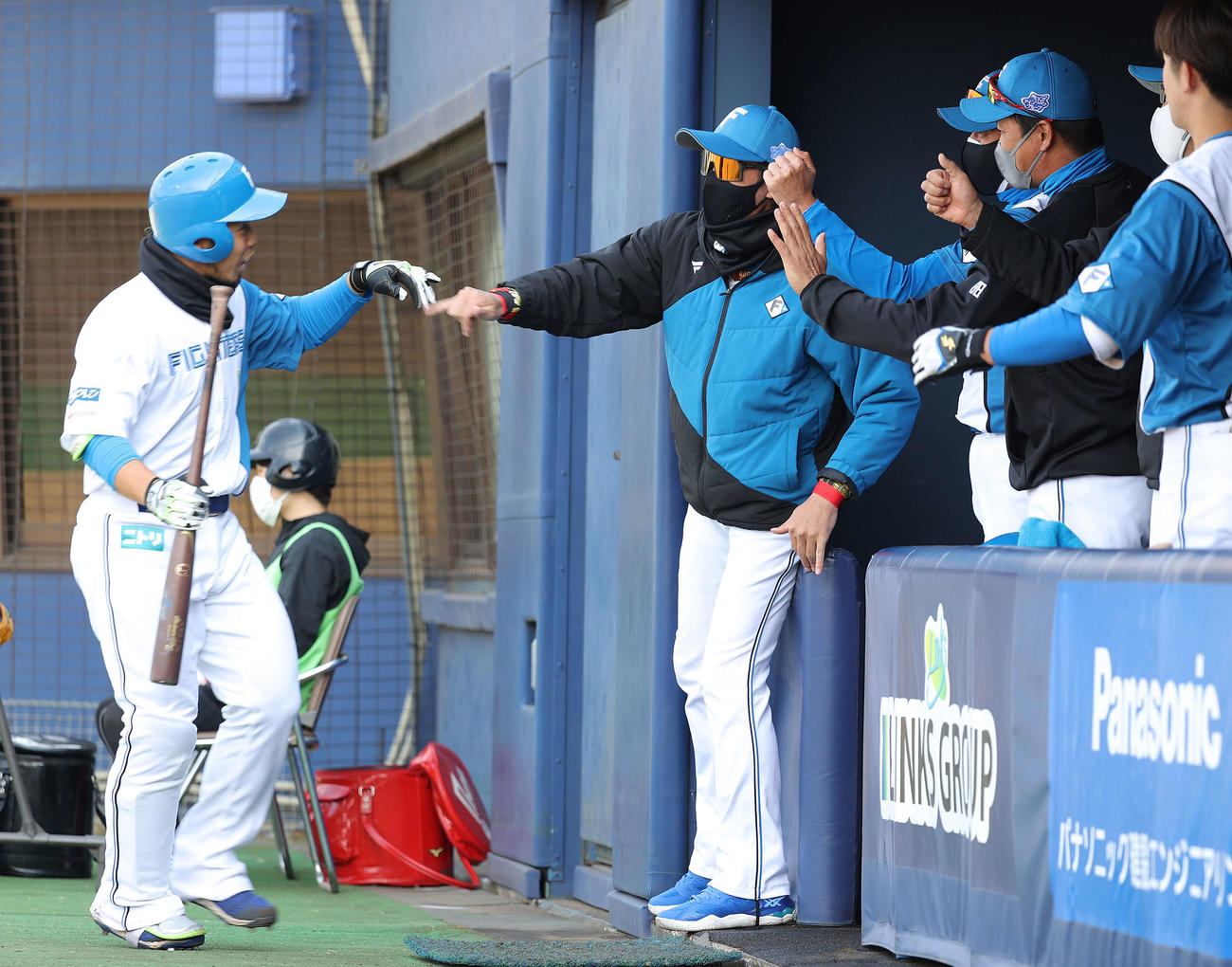 日本ハム対ロッテ　4回裏日本ハム無死一塁、右越え2点本塁打を放った近藤（左端）を迎える新庄監督（左から2人目）（撮影・河野匠）