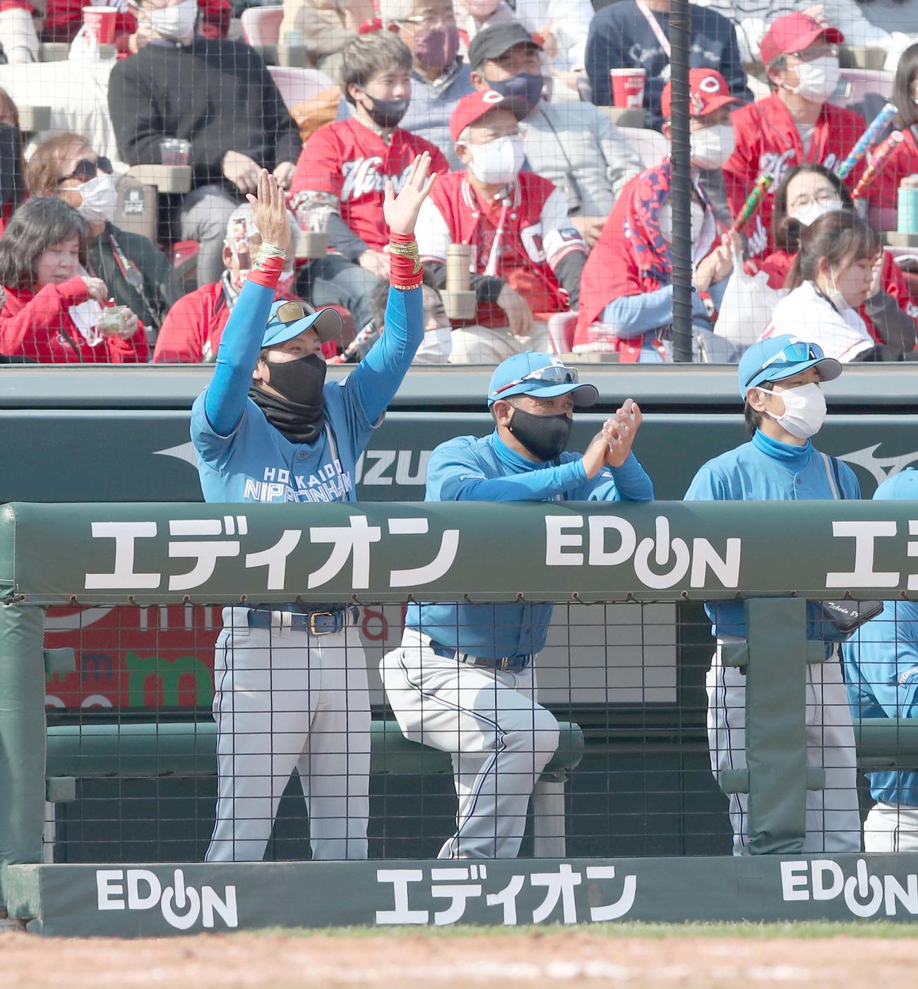 広島対日本ハム　5回裏、近藤の好守に手をたたく新庄監督（左）（撮影・黒川智章）