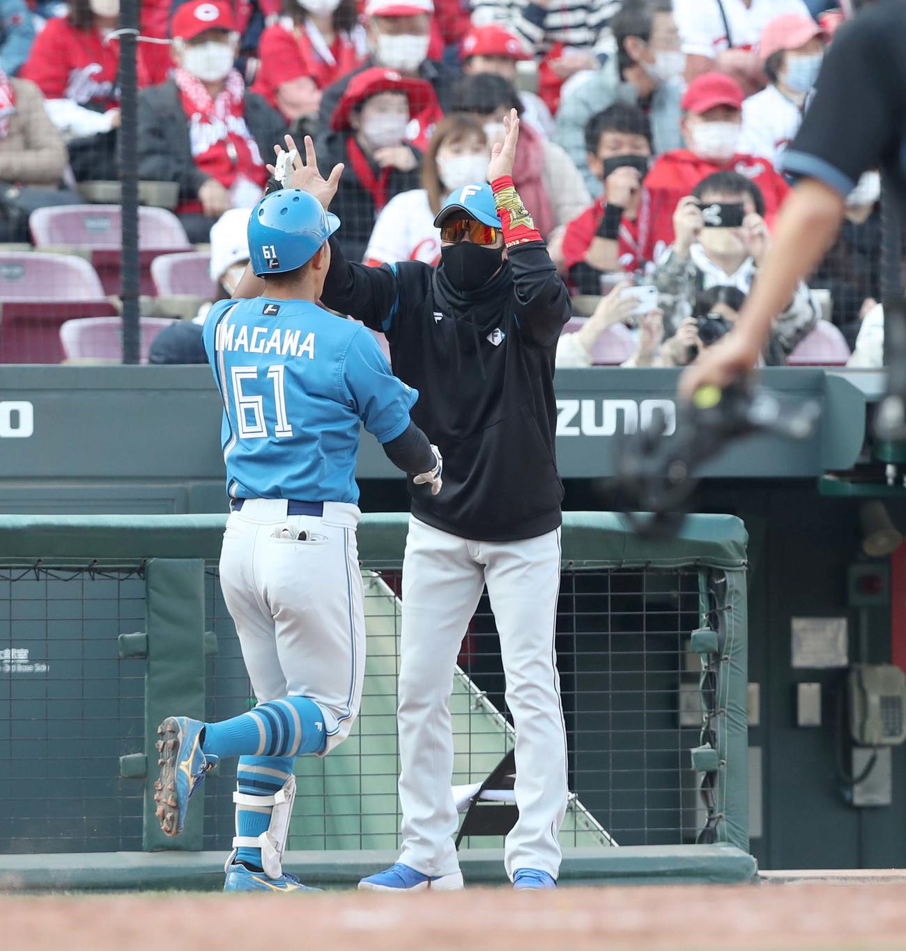 広島対日本ハム　9回表、3点本塁打を放った今川を出迎える新庄監督（撮影・黒川智章）
