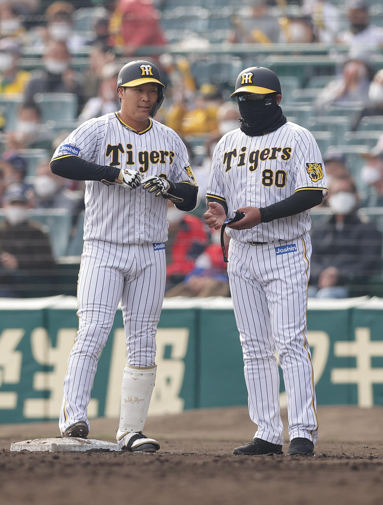 阪神対中日　7回裏阪神1死満塁、中前2点適時打を放った大山（左）は、一塁コーチを務めた北川コーチと会話する（撮影・前田充）