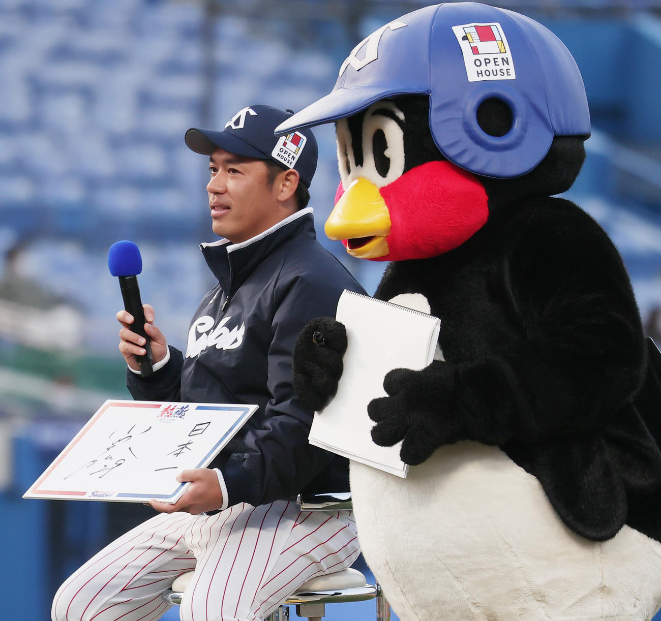 ヤクルト対ソフトバンク　試合後のトークショーで今季の目標を「日本一」と記したヤクルト小川。右はつば九郎（撮影・野上伸悟）