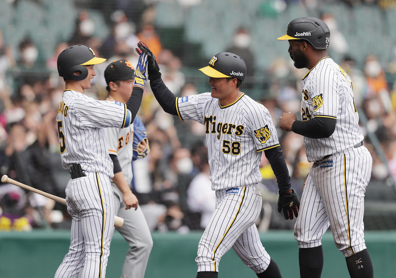 阪神対巨人　7回裏阪神2死一、二塁、小幡の2点適時二塁打で生還し、近本（左）に迎えられる前川。右はロハス（撮影・前田充）