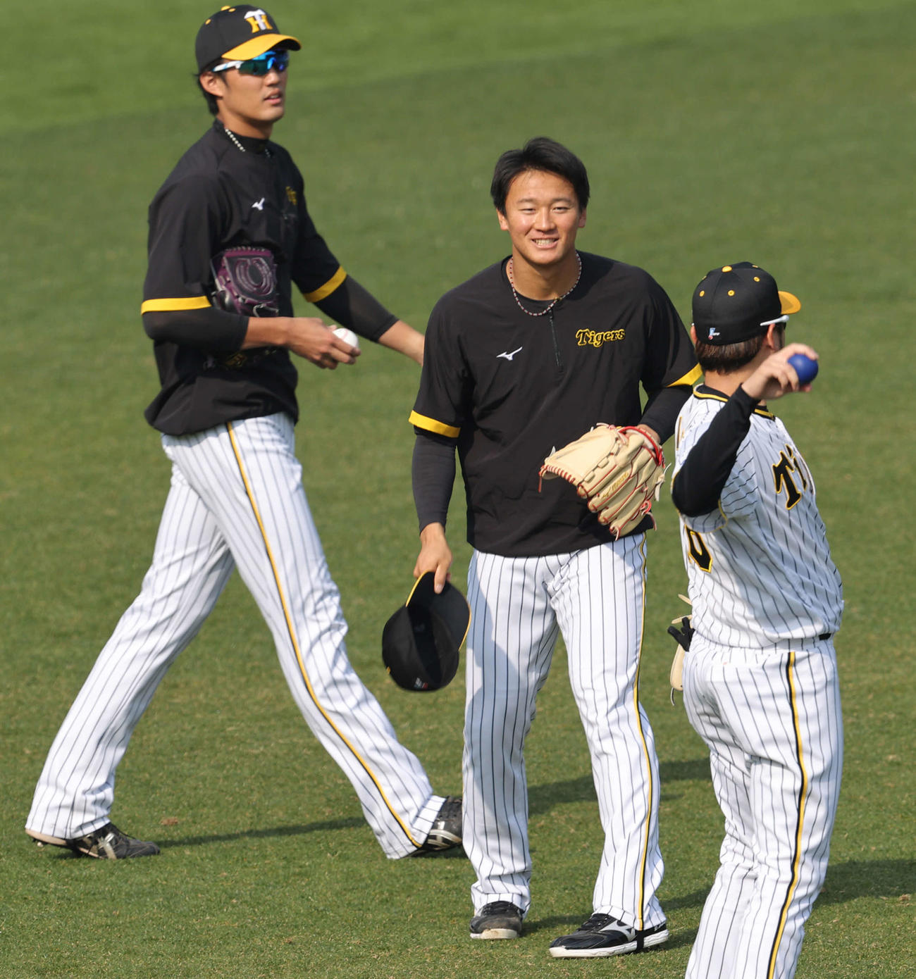 13日、阪神西勇（右）とのキャッチボールで笑顔を見せる森木。左は藤浪