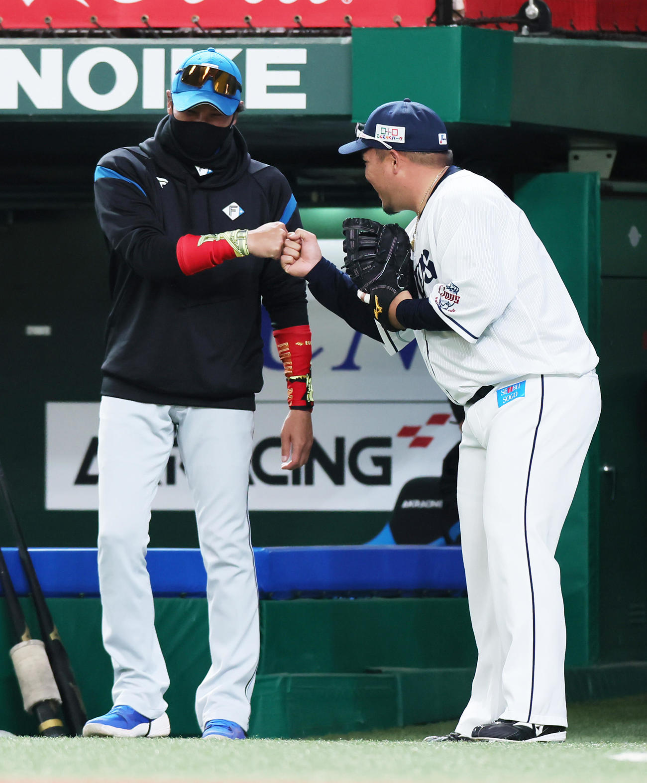 試合前、タッチを交わす日本ハム新庄監督（左）と西武山川（撮影・足立雅史）