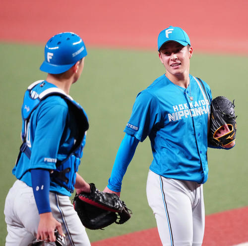 西武対日本ハム　7回裏終了後、日本ハム捕手清水（左）と言葉をかわしながらベンチに引き揚げる3番手の吉田（撮影・江口和貴）