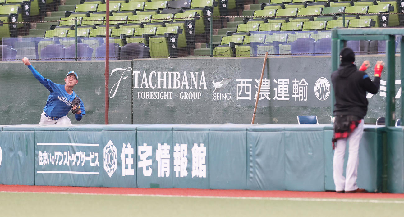 試合前、日本ハム新庄監督（右）が見つめる中、ブルペン投球する姫野（撮影・足立雅史）