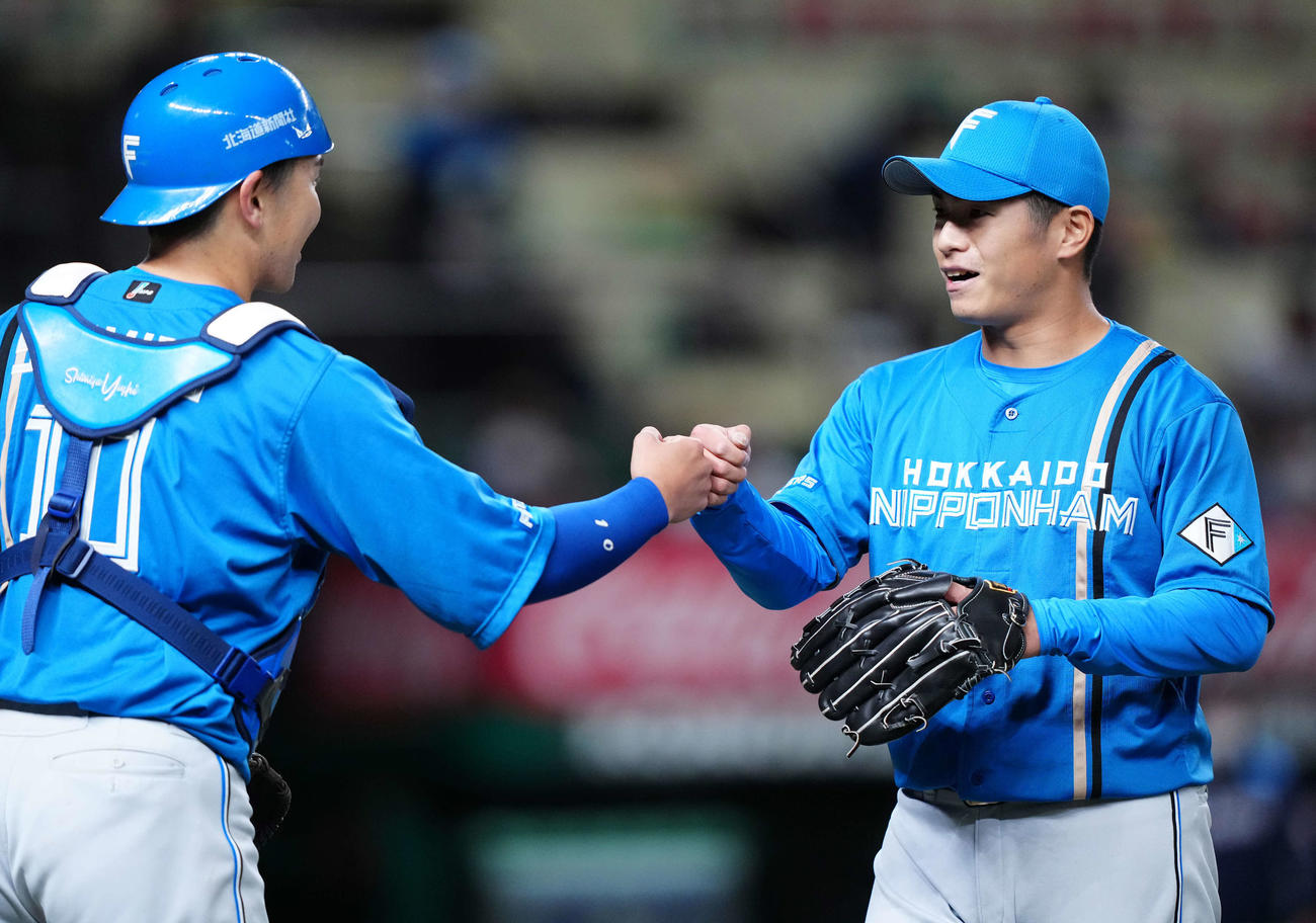 西武対日本ハム　5回裏終了後、日本ハム捕手清水（左）とタッチをかわす2番手の古川侑（撮影・江口和貴）