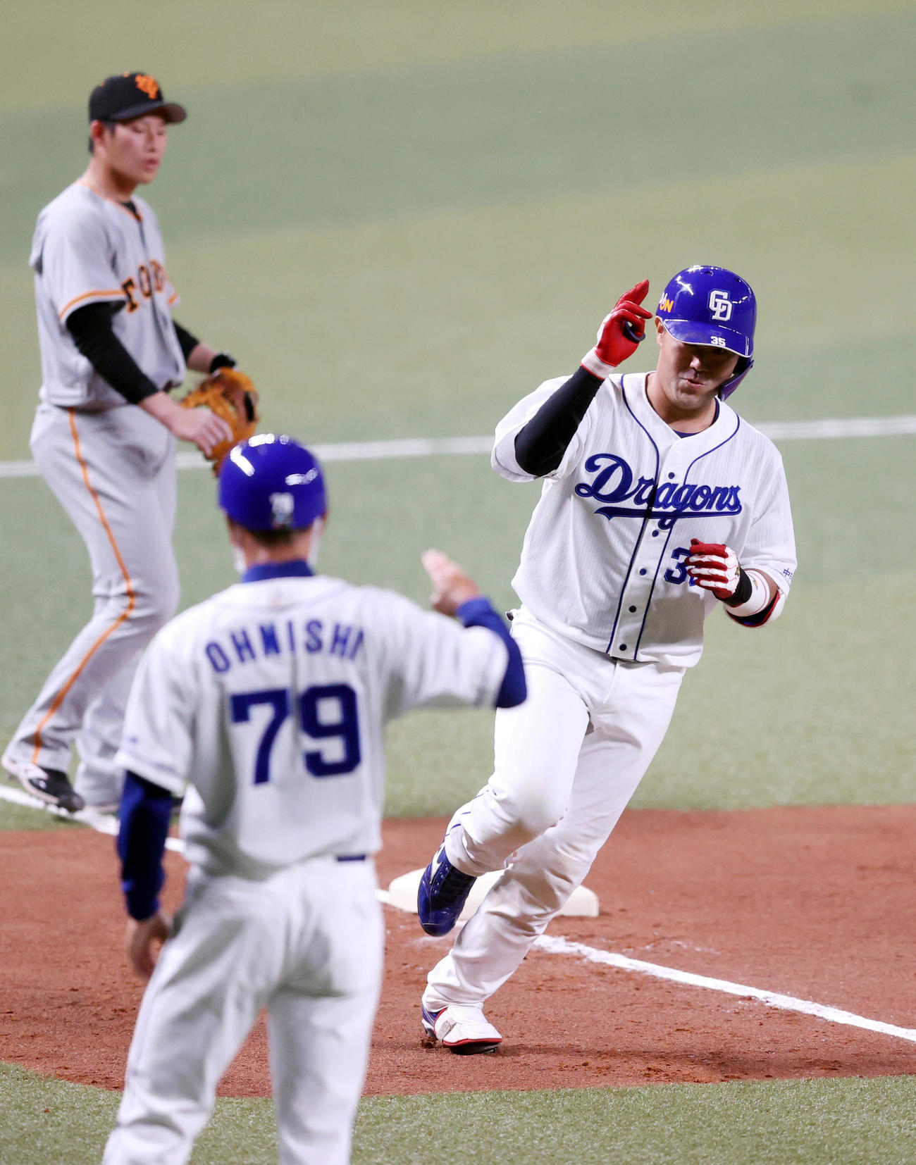中日対巨人　1回裏中日2死満塁、満塁本塁打を放ち、大西コーチ（手前）にポーズを決める木下拓（撮影・狩俣裕三）