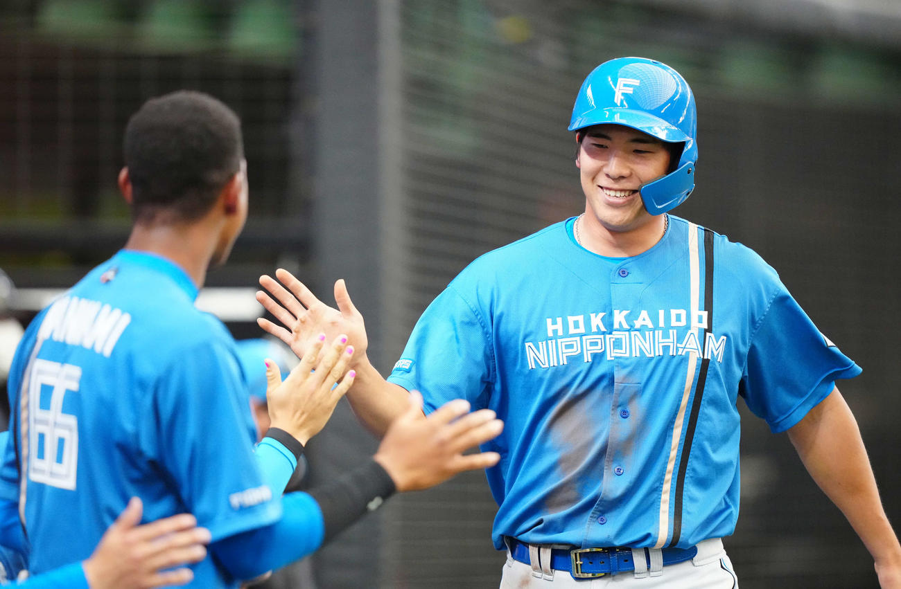 西武対日本ハム　7回表日本ハム2死二塁、渡辺の適時打で生還しチームメートとタッチをかわす速水（右）（撮影・江口和貴）