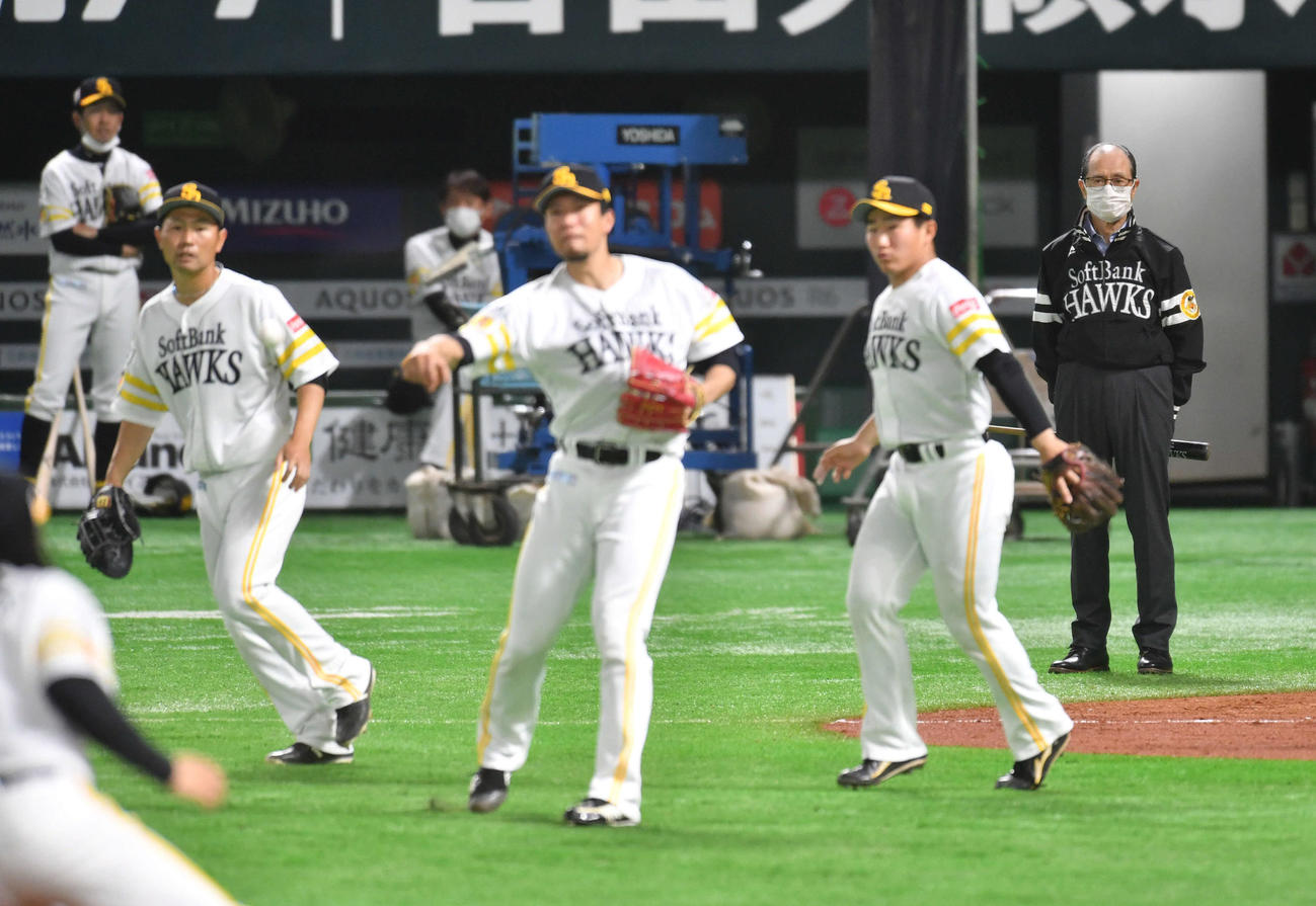 王球団会長（右端）は、サインプレーを行う左から中村晃、千賀、野村大らナインを見つめる（撮影・岩下翔太）