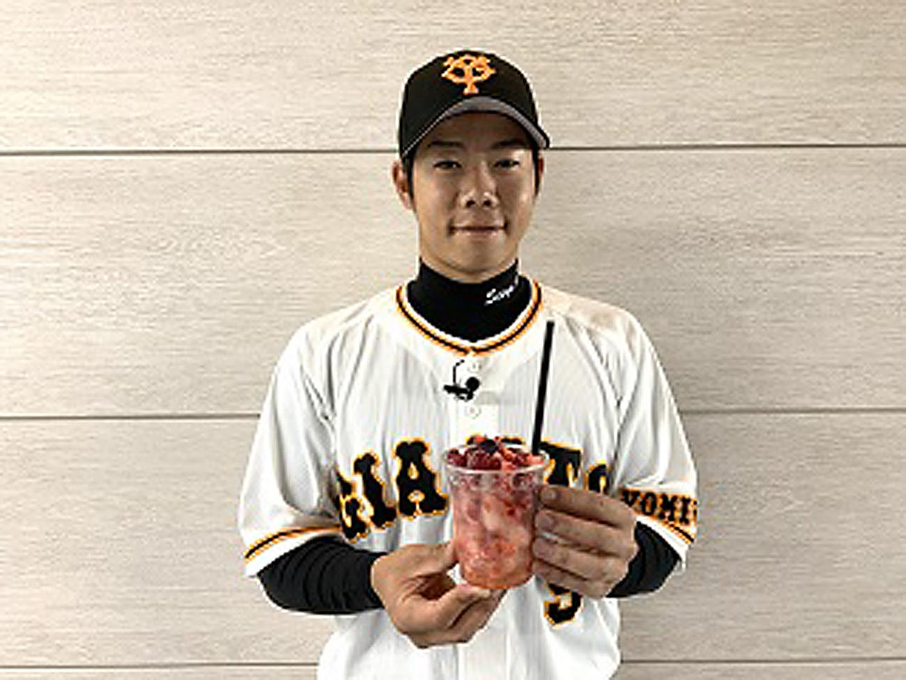 「松原聖弥の爽快！ベリー＆ベリーソーダ」を持ち、笑顔を見せる巨人松原（球団提供）