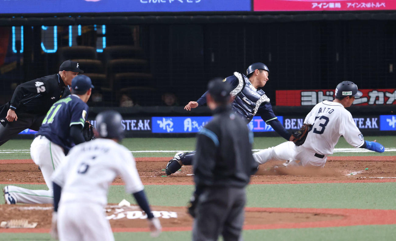 西武対ヤクルト　5回裏西武2死一、三塁、源田（手前）が二盗し、その送球間に三塁走者の愛斗が生還を果たす。捕手古賀（撮影・河野匠）