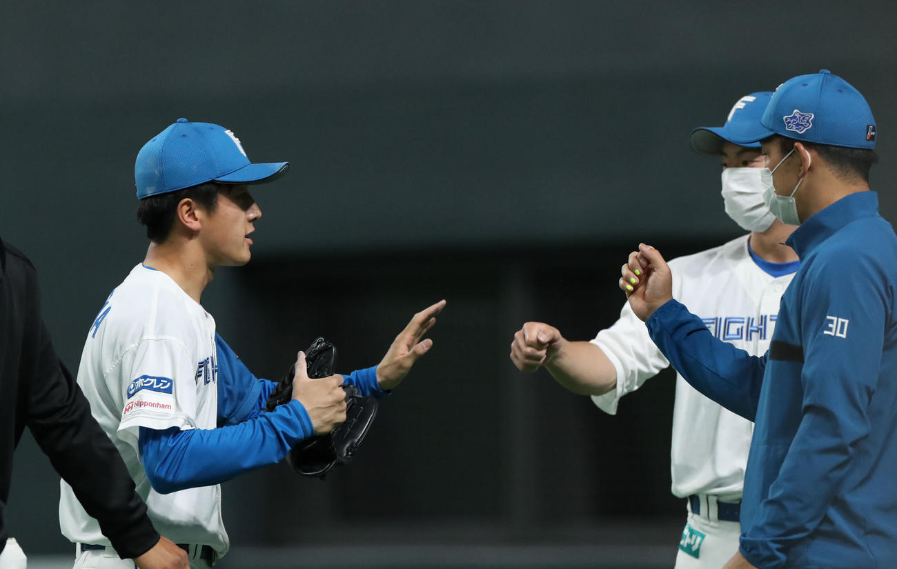 日本ハム対DeNA 9回表を無失点に抑えチームメートに出迎えられる日本ハム北山（左）（撮影・佐藤翔太）