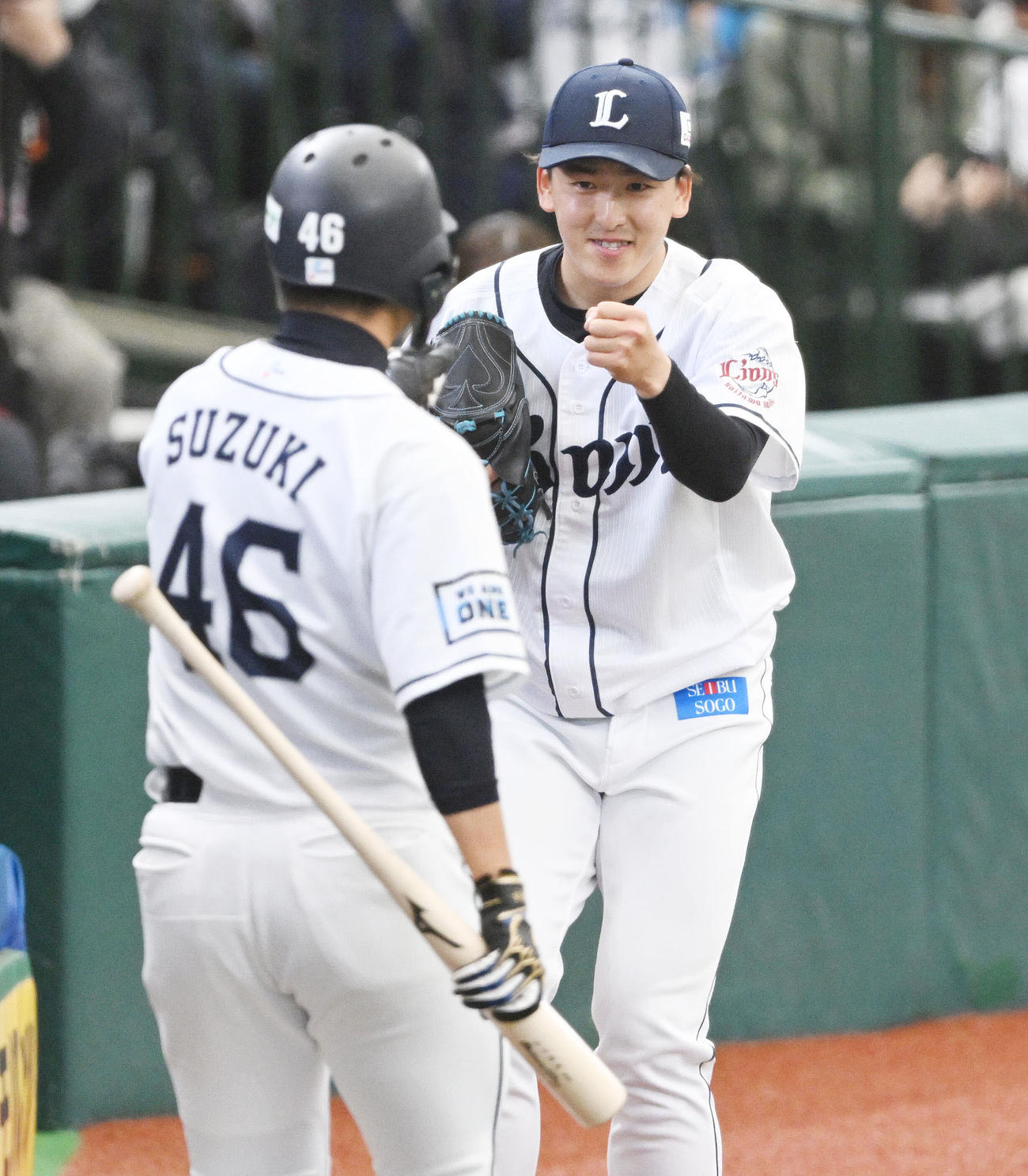西武対ヤクルト　3回裏西武2死一、三塁、山川の適時打から生還した鈴木（手前）を迎える隅田（撮影・滝沢徹郎）