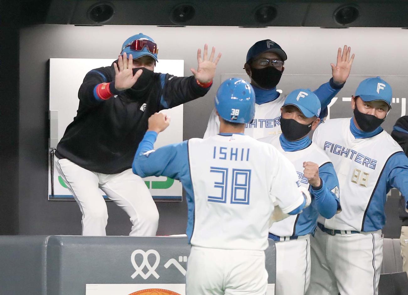 日本ハム対DeNA 8回裏、生還した石井を出迎える新庄監督（左）（撮影・黒川智章）