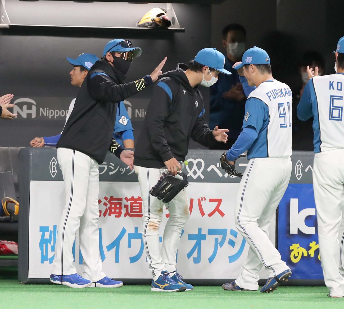 日本ハム対DeNA 6回表、無失点に抑えた古川侑（右）を出迎える日本ハム新庄監督（撮影・黒川智章）