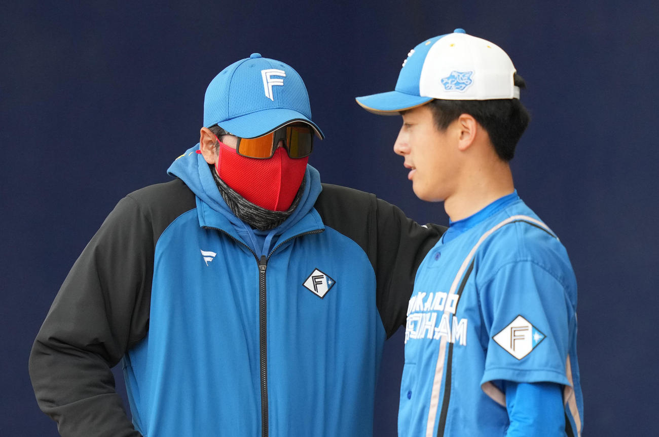 ブルペンで日本ハム北山（右）に声をかける新庄監督（2022年2月18日撮影）