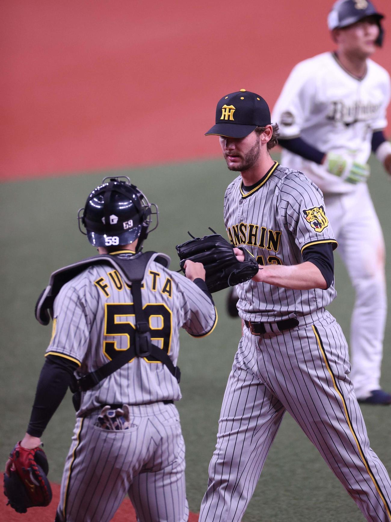 練習試合　オリックス対阪神　オリックス打線を1イニング無失点に抑えたケラー（右）は藤田とグラブタッチする（撮影・上田博志）