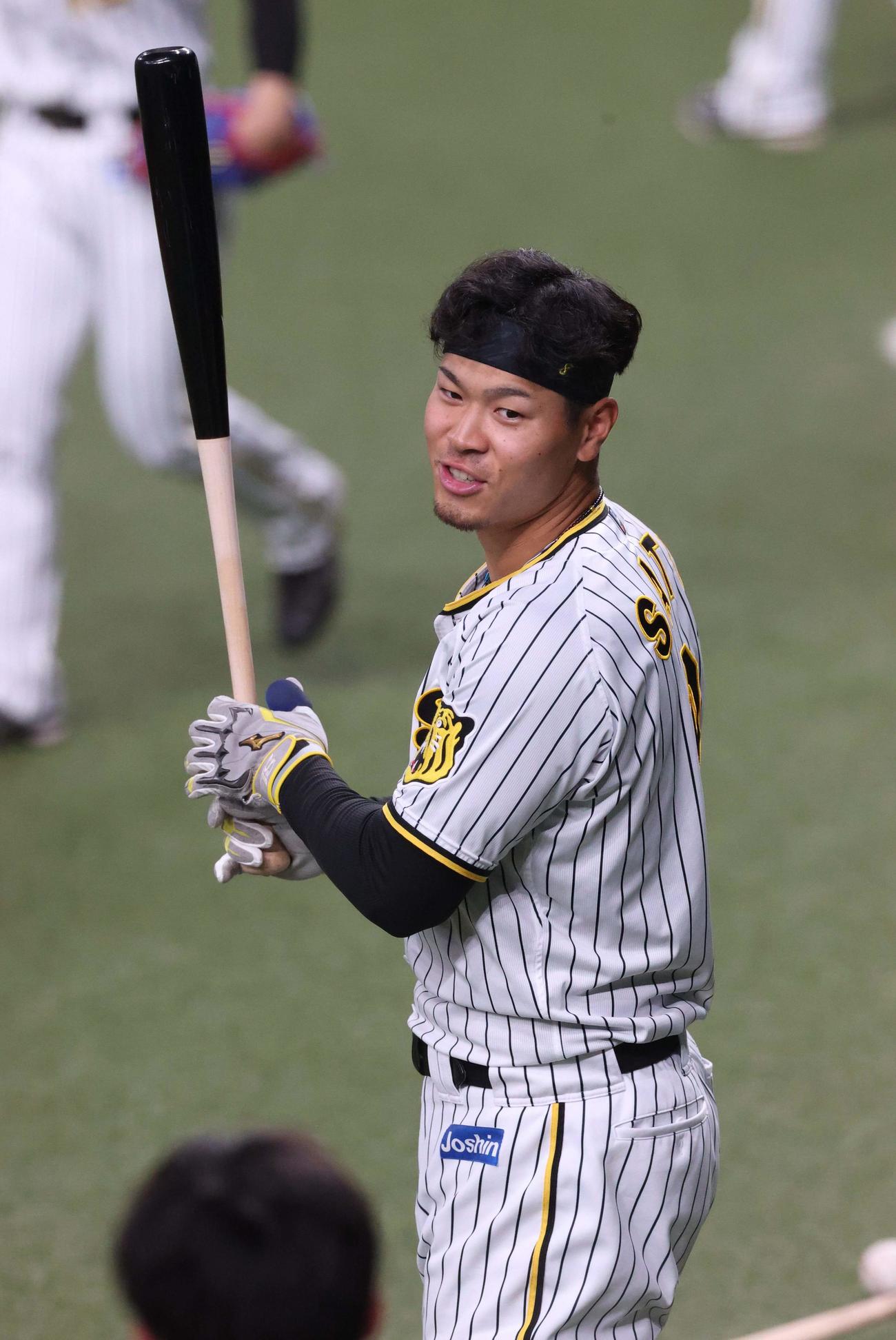 バットを手に笑顔を見せる佐藤輝（撮影・上田博志）