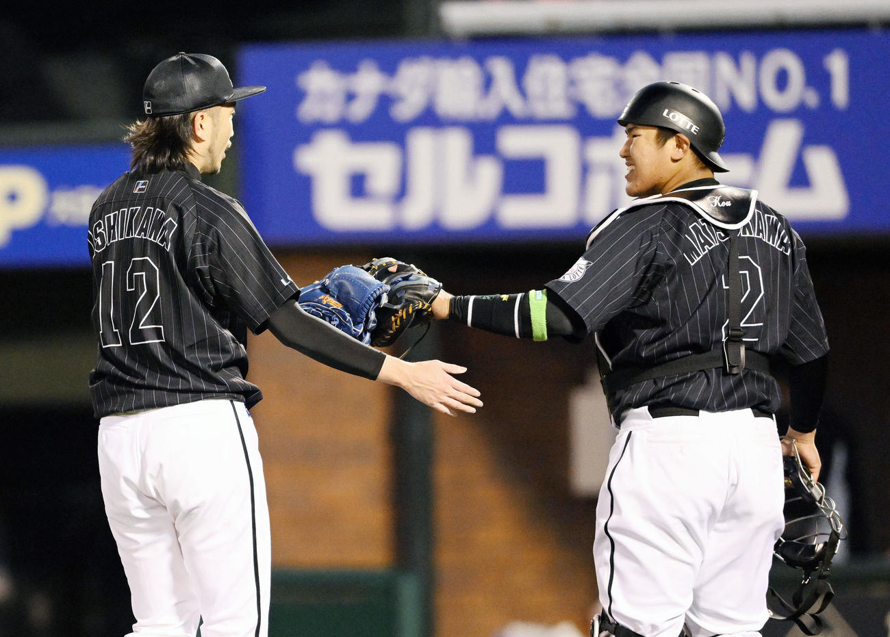 楽天対ロッテ　7回を投げ終えたロッテ先発の石川（左）は捕手松川とタッチを交わす（撮影・滝沢徹郎）
