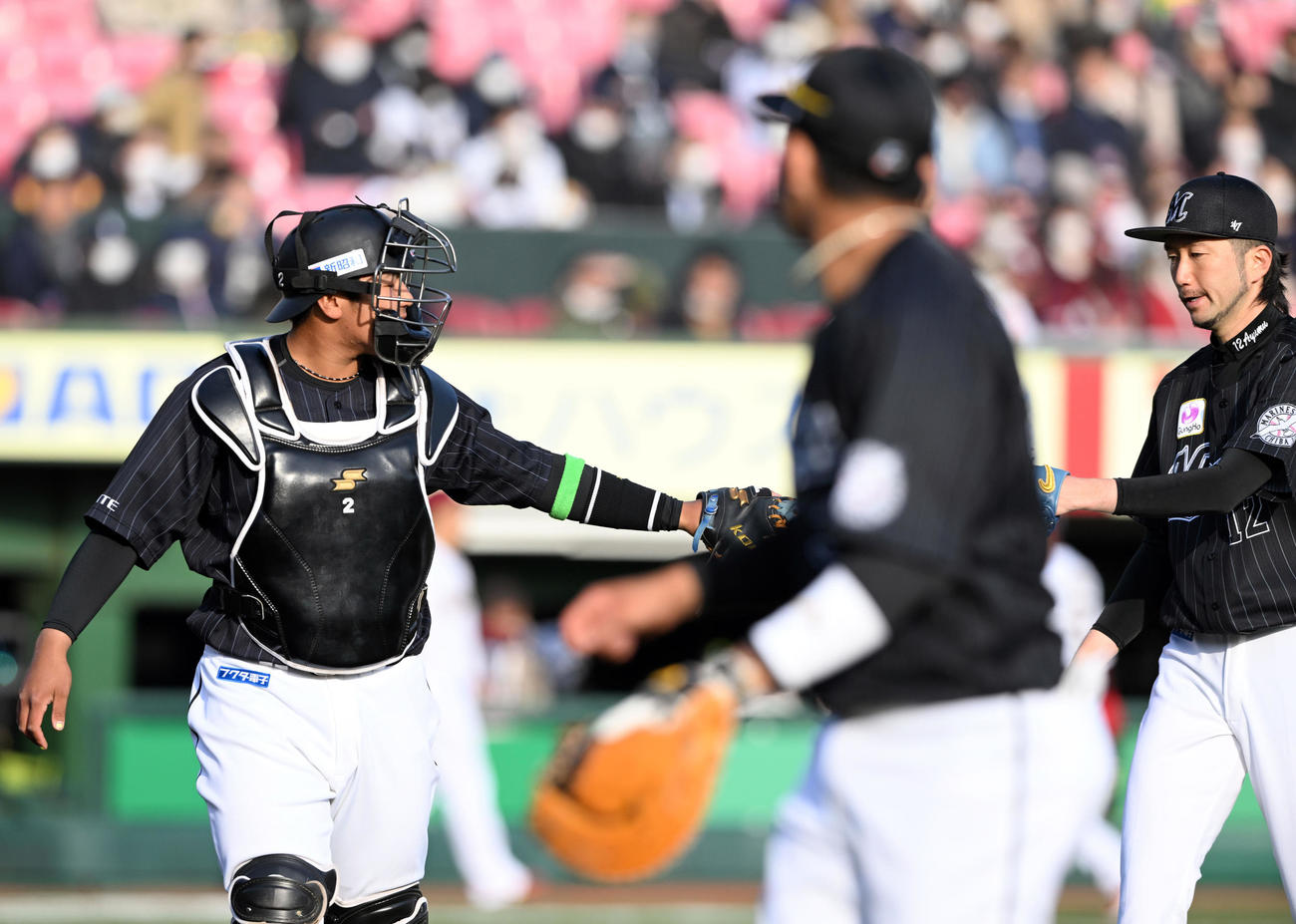 楽天対ロッテ　1回を投げ終えたロッテ先発の石川（右）とタッチを交わす松川（撮影・滝沢徹郎）