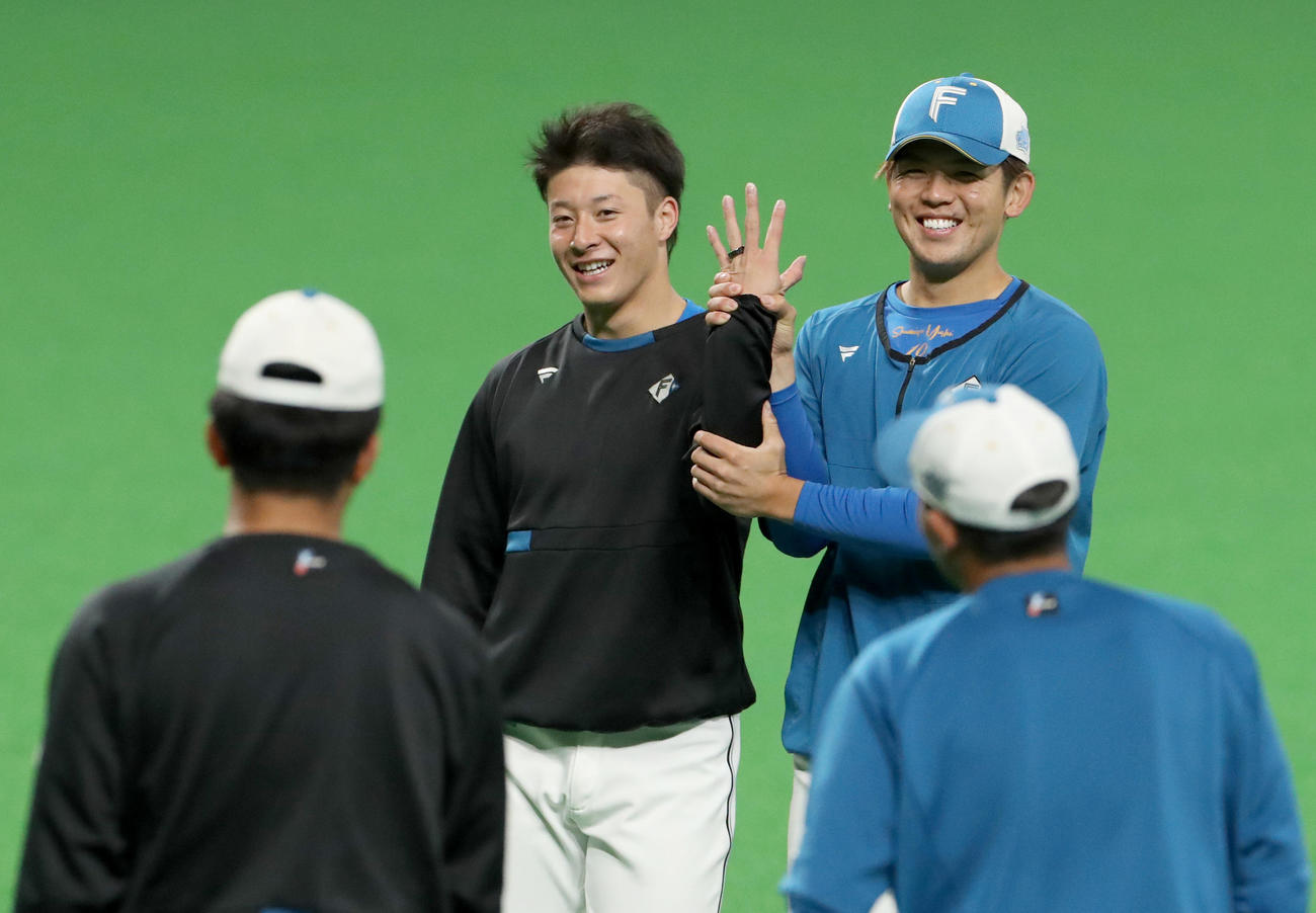 日本ハム吉田（中央）は清水にオーラリングを結婚指輪のように左手薬指につけられる（撮影・佐藤翔太）
