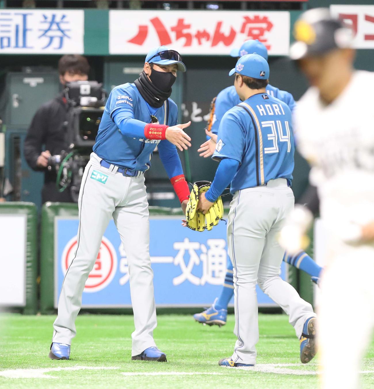 ソフトバンク対日本ハム　1回裏を投げ終えた堀を出迎える新庄監督（撮影・黒川智章）