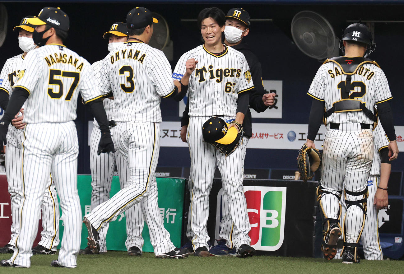 阪神対ヤクルト　8回に登板の湯浅（右から3人目）は3者凡退に抑えベンチ前で笑顔を見せる（撮影・上山淳一）