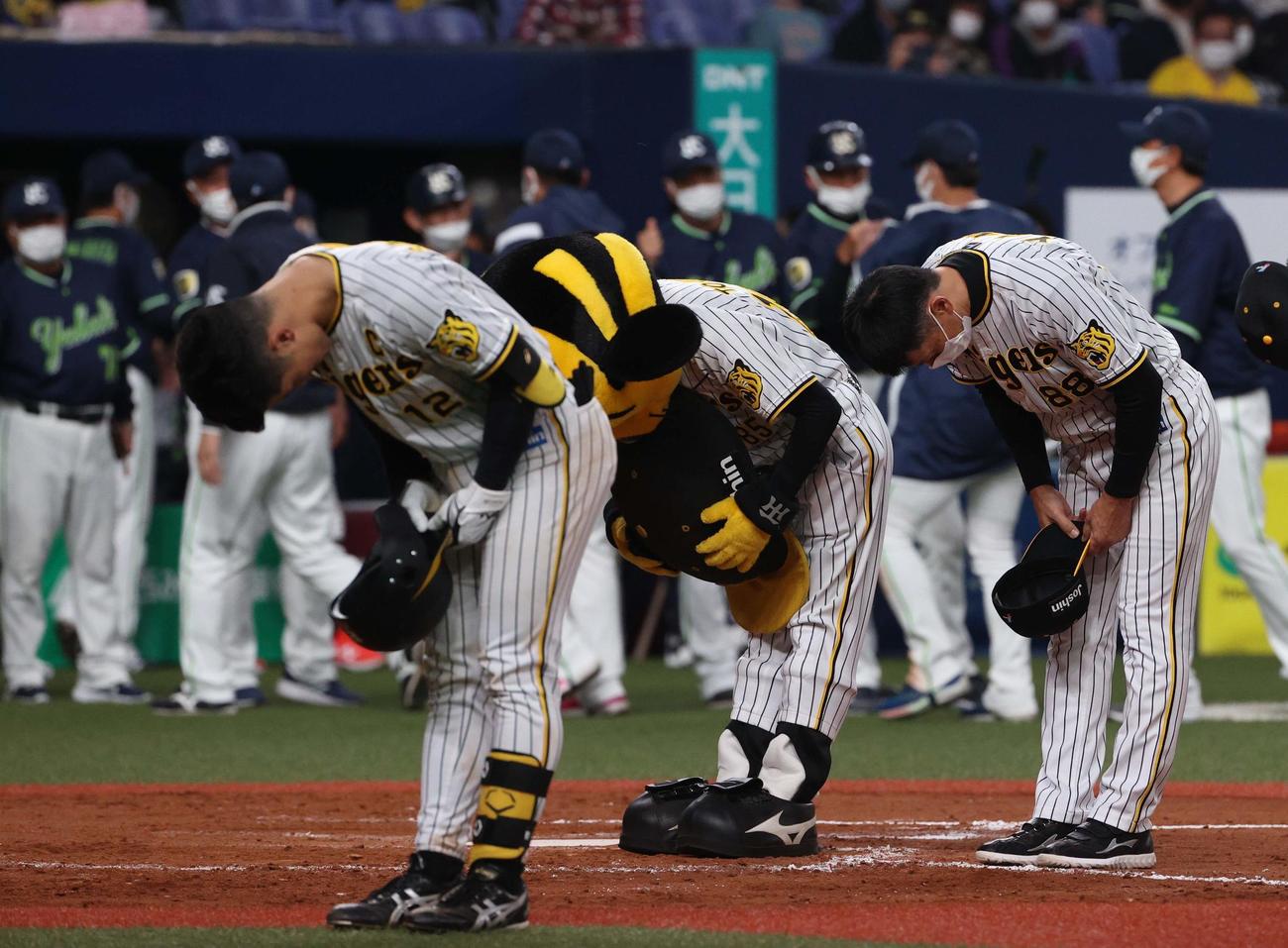 阪神対ヤクルト　ヤクルトに連敗しファンに頭を下げる坂本主将（左）と矢野監督（撮影・上田博志）