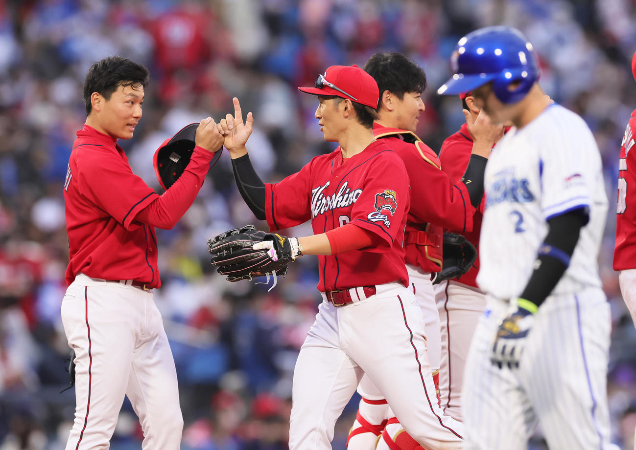 DeNA対広島　開幕3連勝を飾りタッチを交わす広島の栗林（左）と西川。手前右はDeNA牧（撮影・足立雅史）
