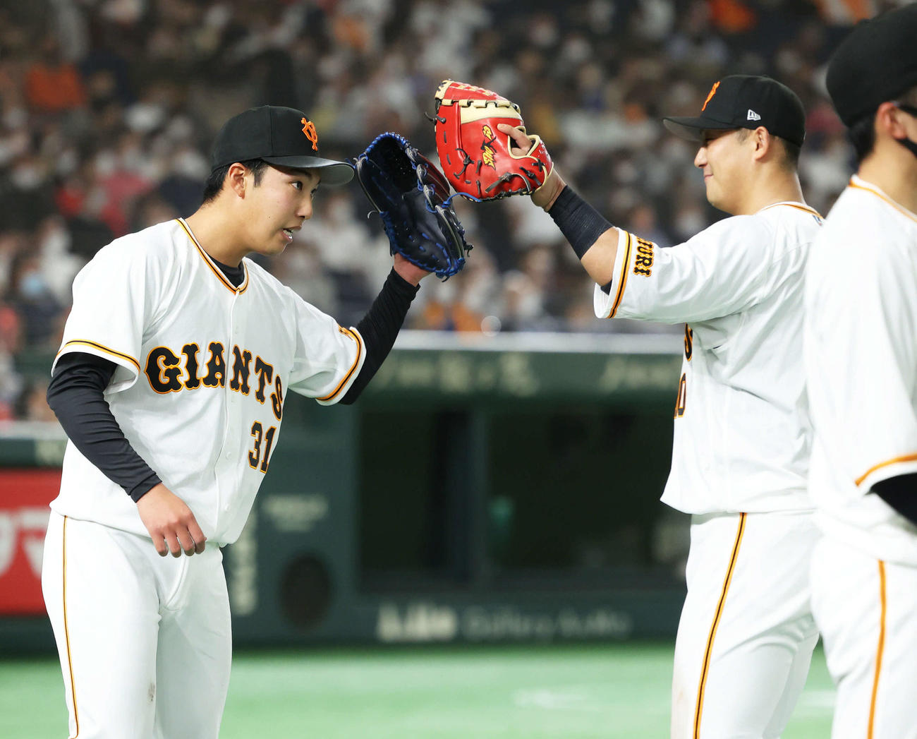 6回表を抑え、グラブタッチを交わす赤星（左）と中田（撮影・河田真司）