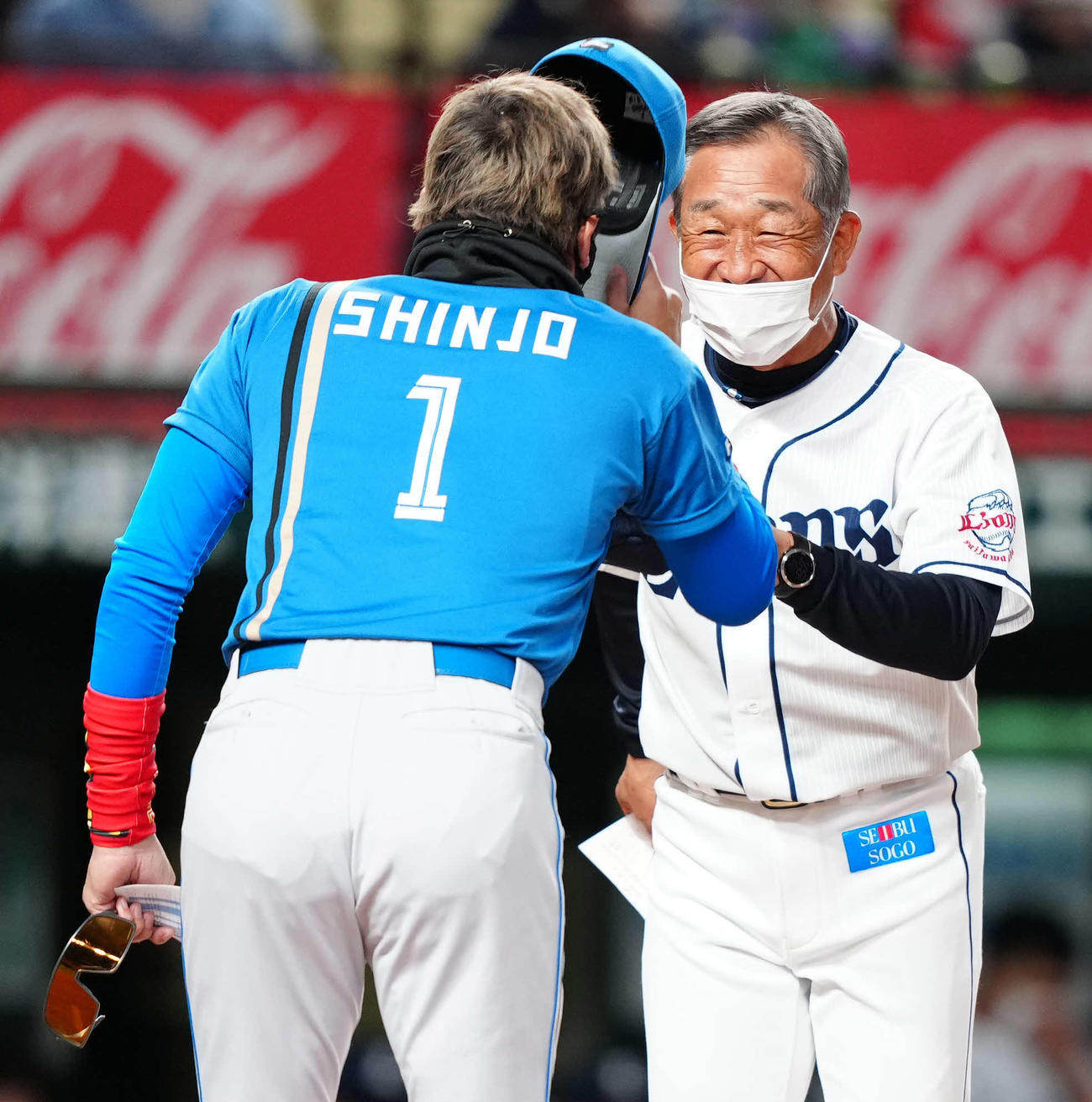 試合前、日本ハム新庄剛志監督（左）とあいさつをかわし笑顔を見せる西武辻発彦監督（2022年3月15日撮影）
