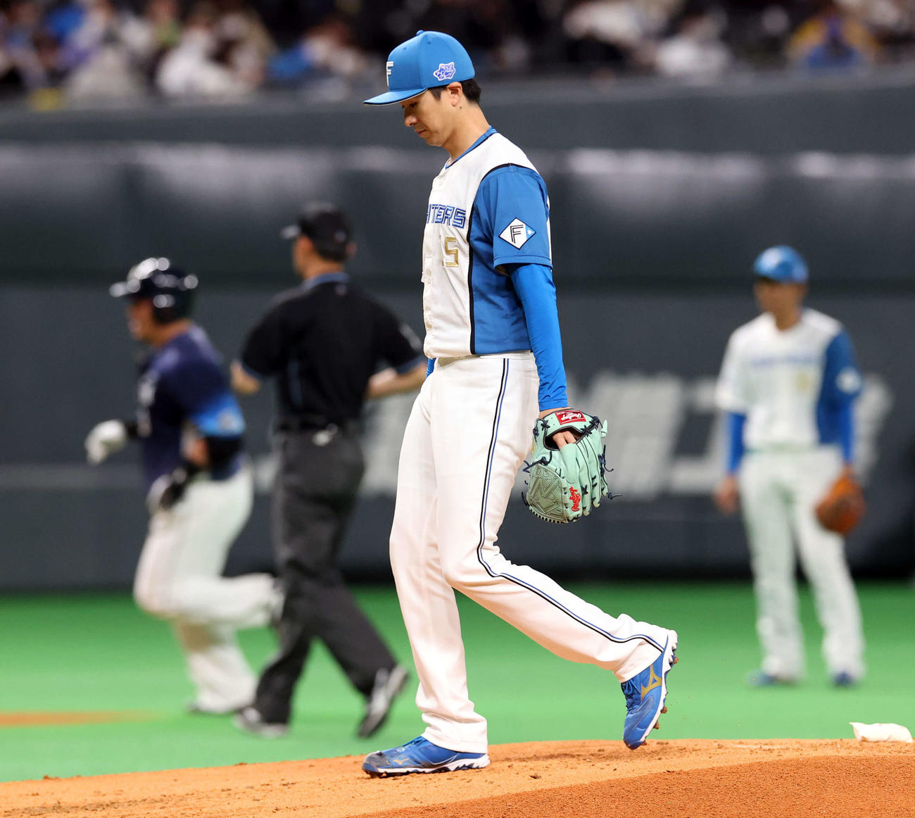日本ハム対西武　2回表西武無死、山川（後方）に先制本塁打を許し、うつむく上沢（撮影・浅見桂子）