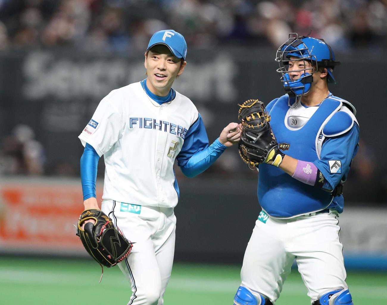 日本ハム対西武　7回表、無失点に抑え笑顔の宮西（左）（撮影・黒川智章）