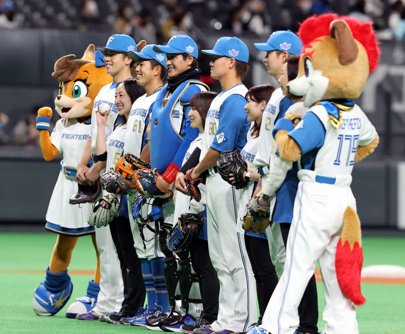 日本ハム対西武　ロコ・ソラーレのファーストピッチセレモニーで、捕手の装備で登場した日本ハム新庄監督（中央）は笑顔で記念撮影（撮影・浅見桂子）
