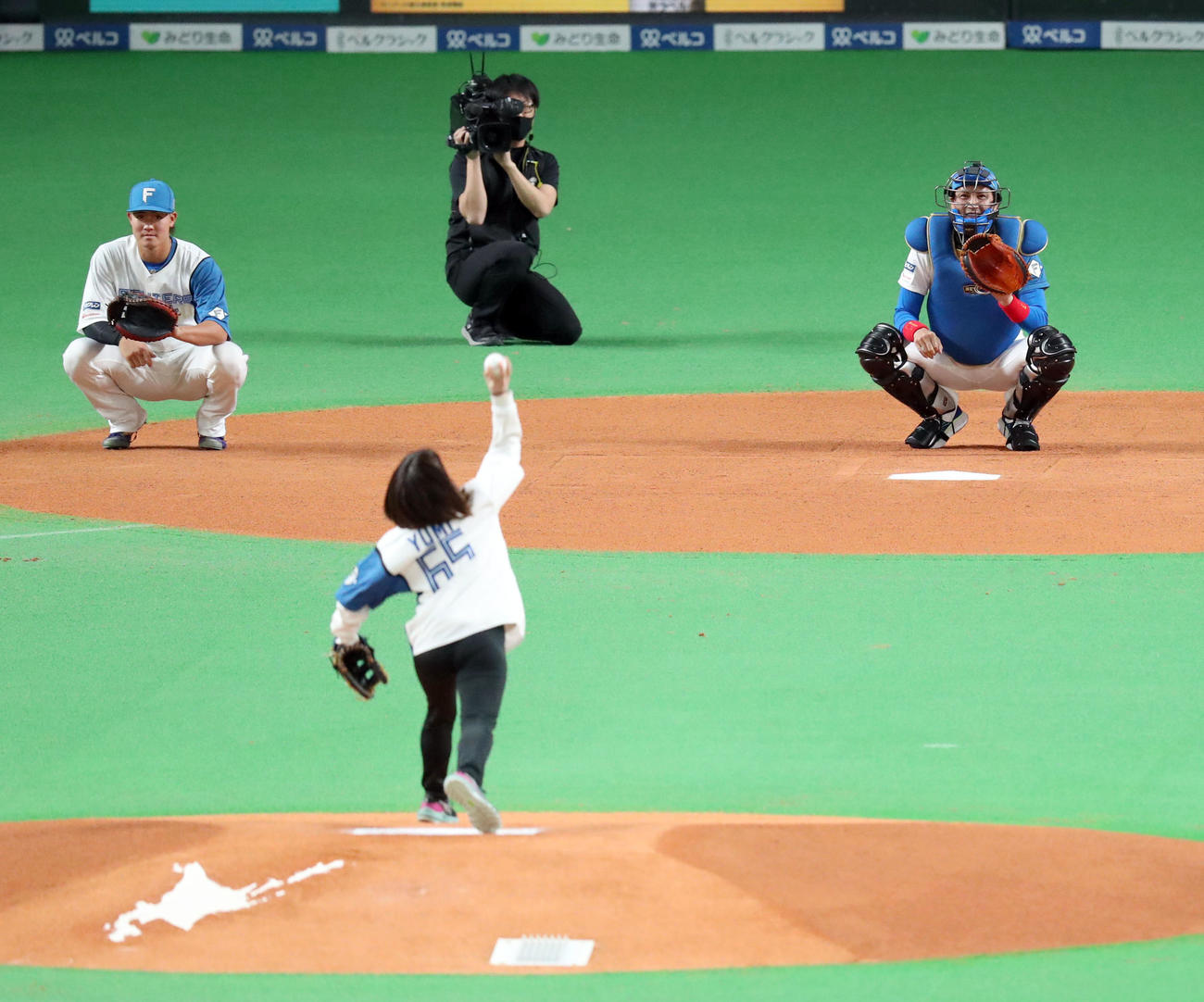 日本ハム対西武　ファーストピッチセレモニーでロコ・ソラーレの鈴木の球を受ける日本ハム新庄監督（右後方）（撮影・佐藤翔太）
