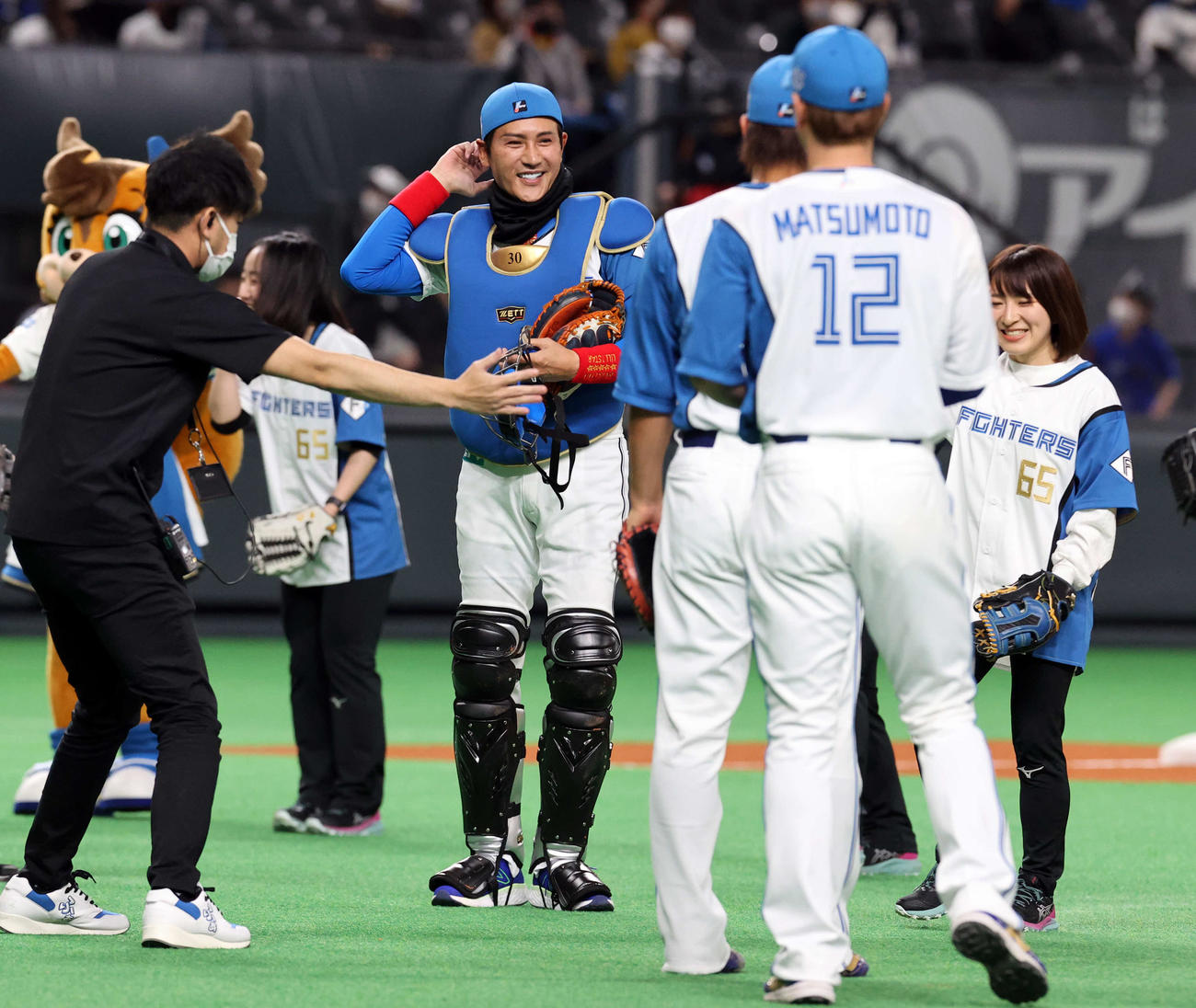 日本ハム対西武　ファーストピッチセレモニーで、捕手の装備で登場した日本ハム新庄監督（中央）は笑顔で記念撮影に向かう（撮影・浅見桂子）