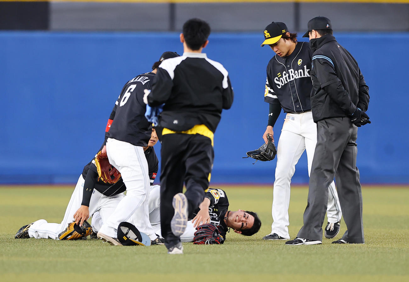 ロッテ対ソフトバンク　9回裏ロッテ2死、福田光の打球を追いかけ上林と交錯した栗原（中央）は左ヒザ付近を押さえながら痛がる（撮影・垰建太）