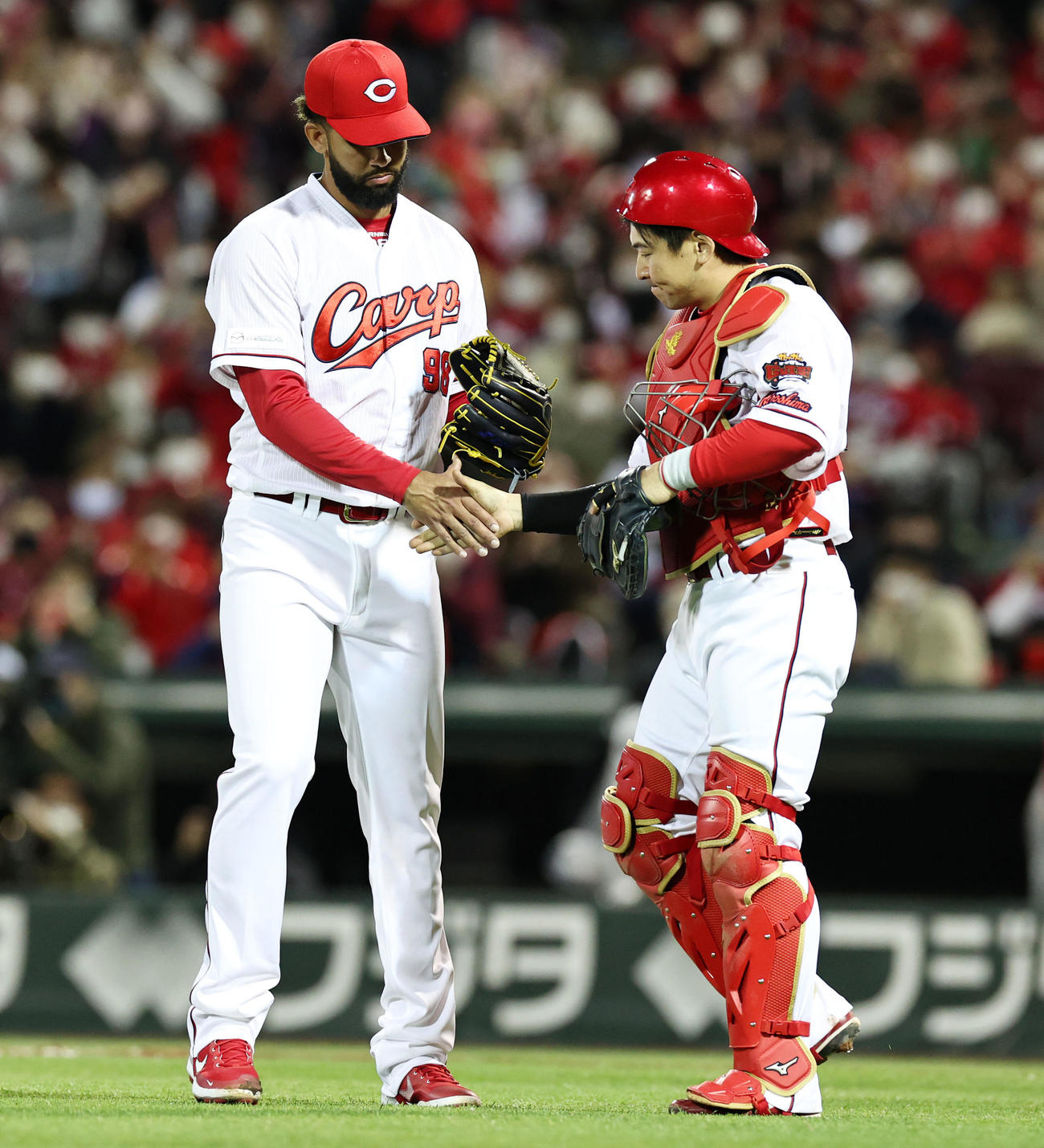 広島対阪神　9回に登板し阪神に勝利したコルニエル（左）は会沢と握手する（撮影・加藤哉）