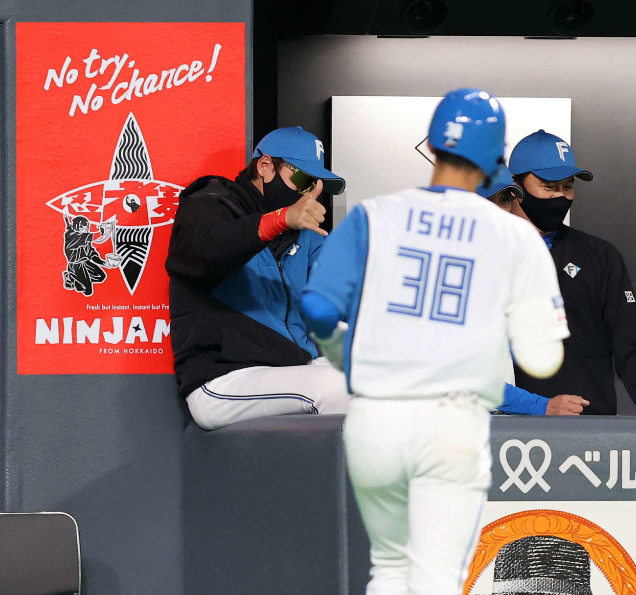 日本ハム対西武　4回裏日本ハム無死一塁、石井（手前）が送りバントを決め、BIGBOSSポーズで迎える新庄監督（撮影・浅見桂子）