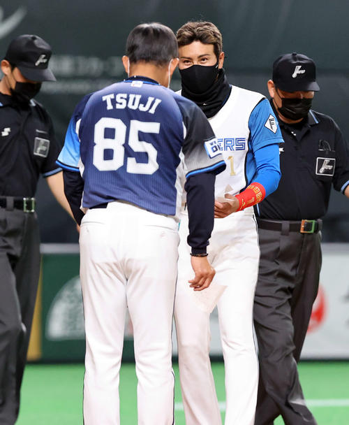 日本ハム対西武 試合開始前、最終のメンバー確認をする西武辻監督(手前)と日本ハム新庄監督(撮影・浅見桂子)
